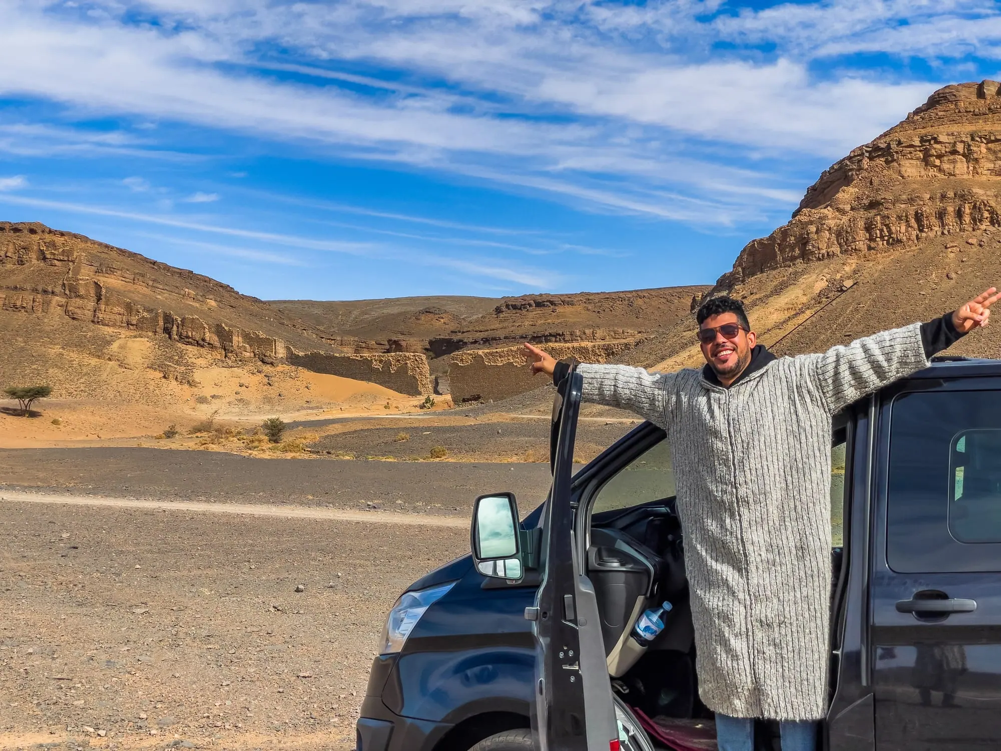 Veículo 4x4 parado num vale de montanhas a caminho do deserto, Marrocos